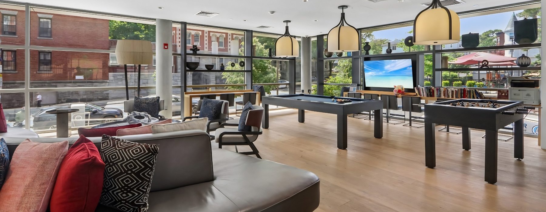 a clubroom with a couch, pool tables and chairs
